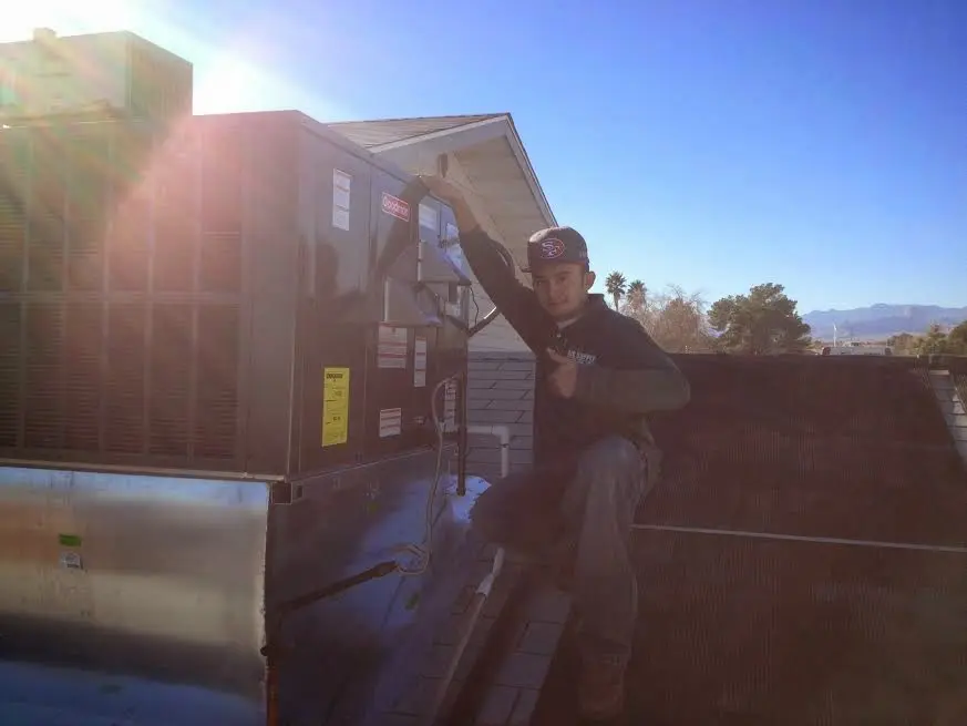 HVAC technician performing AC Tune-Up on a rooftop unit in Samsula-Spruce Creek